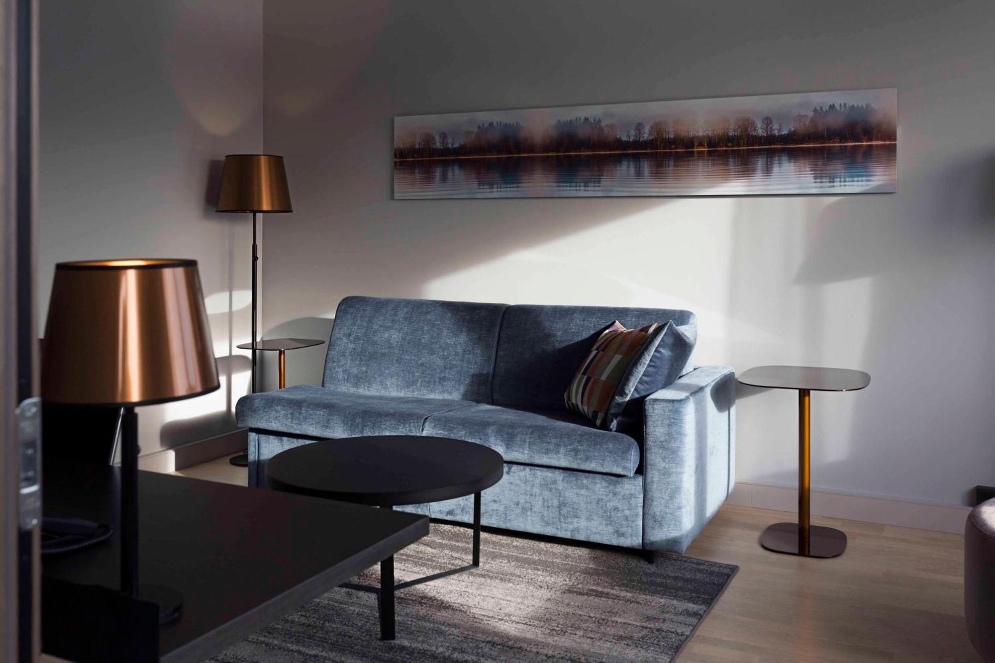 Hilton Helsinki Strand Exterior photo A living room with a blue sofa